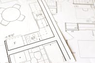 Close-up view of an architectural floor plan on paper showcasing detailed room layouts and measurements.